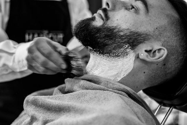 barber trimmng a beard in a barber shop